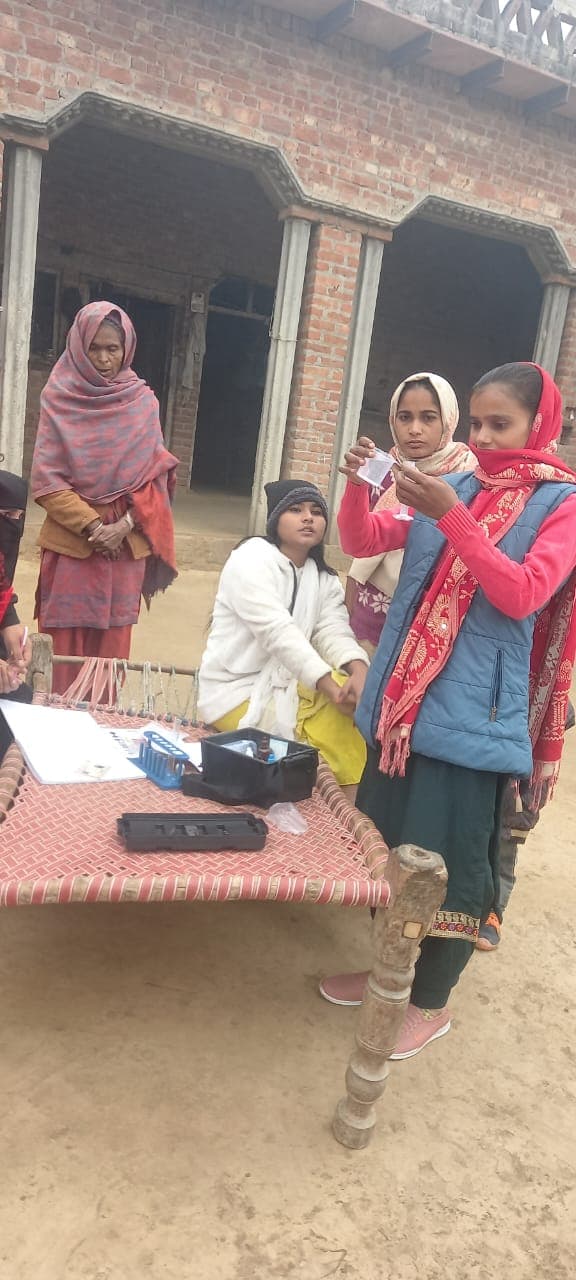 Students and residents testing water with the Jaljyoti kit in a village